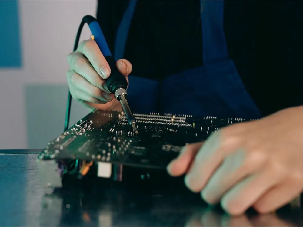 Technician inspecting and assembling a printed circuit board